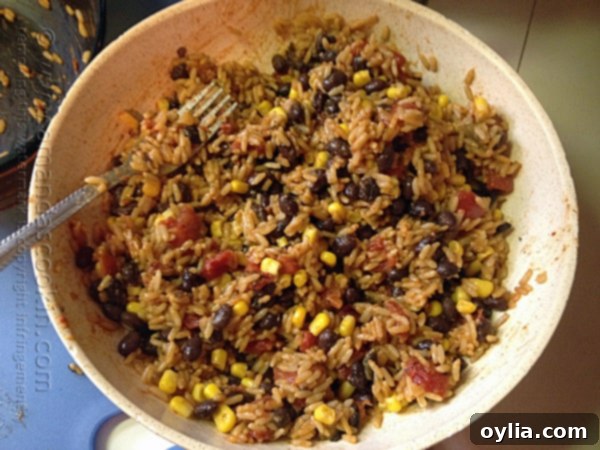 A bowl of Spanish rice with black beans and corn stirred in, still hot.