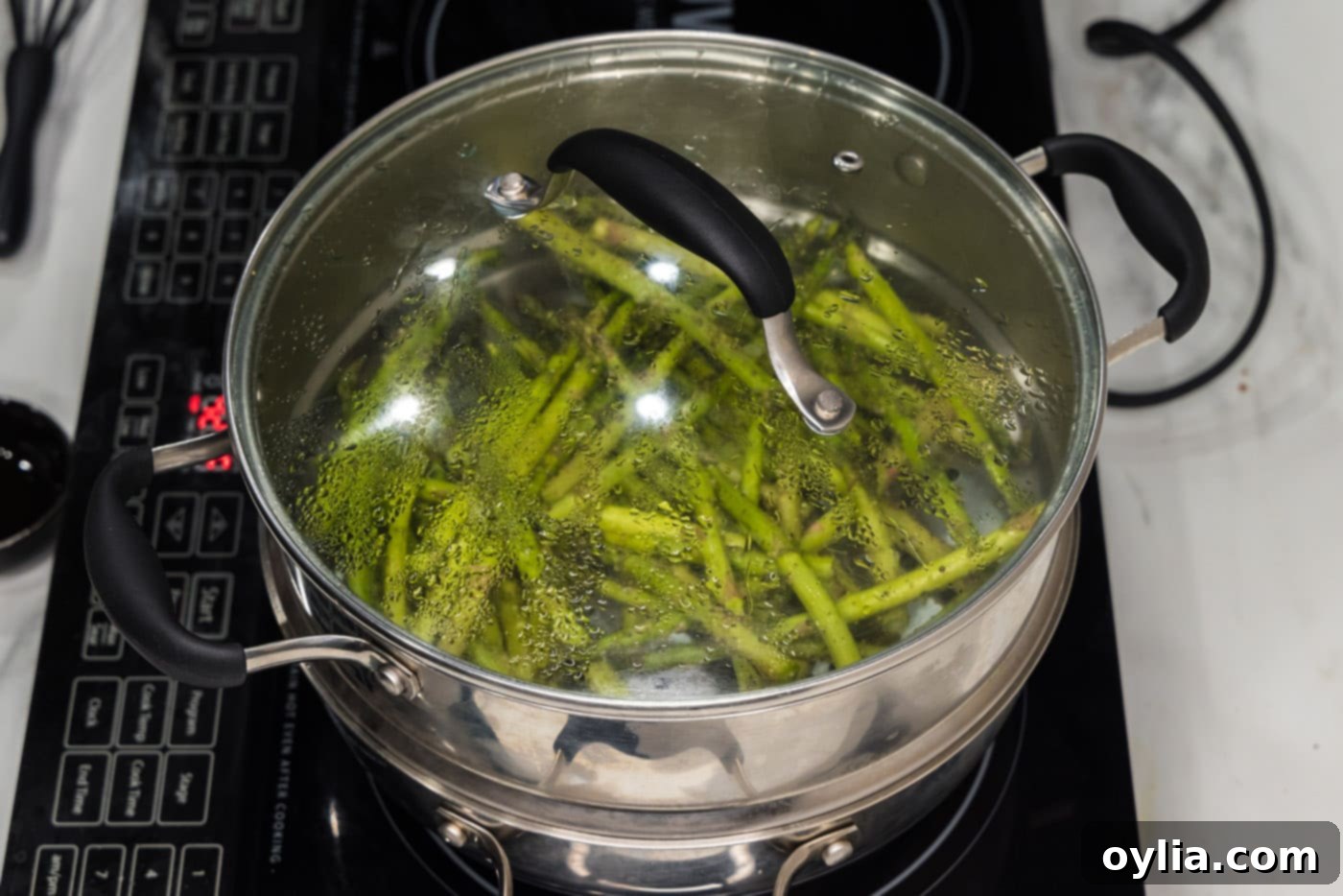 lid covering asparagus spears in a steam pot