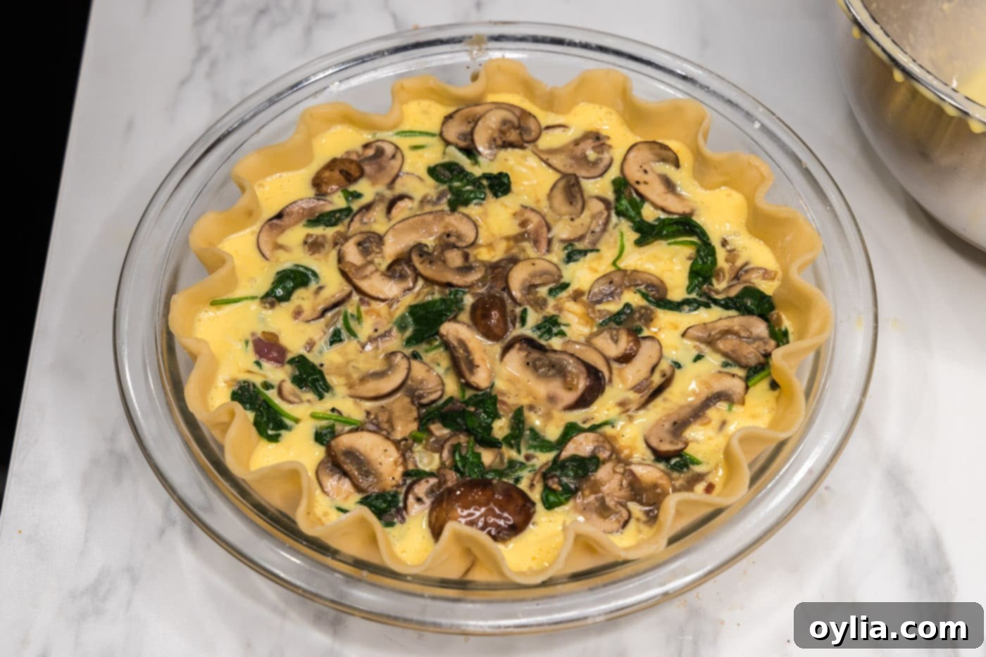 layer of spinach and mushrooms over egg filling in a pie plate