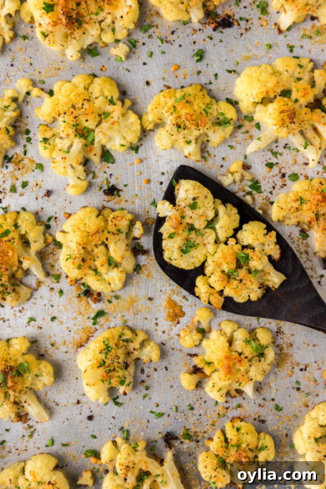 Savory Cauliflower Smash 3 Close up photo of Smashed Cauliflower on a sheet pan with a spatula
