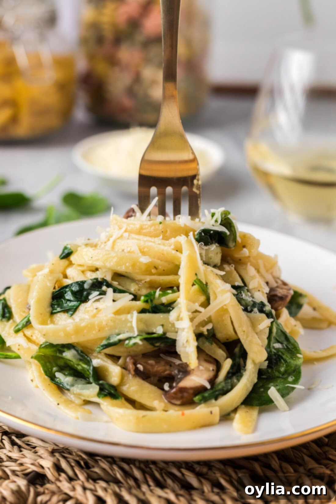 Fresh Spinach Fettuccine 12 A fork taking a generous portion of Spinach Fettuccine from a plate, showing the creamy sauce and fresh ingredients