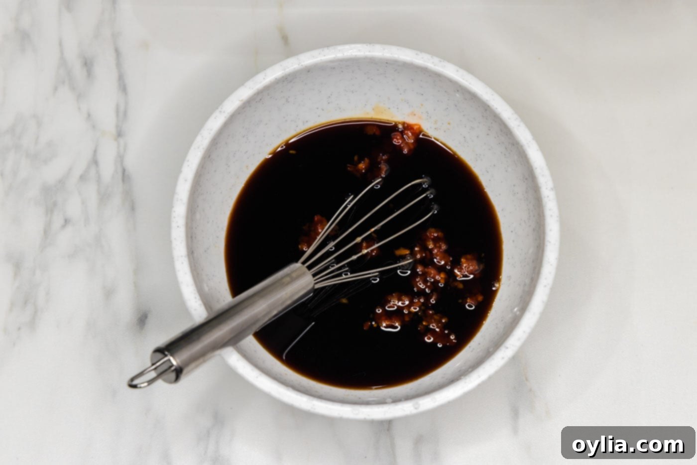 pad thai sauce in a bowl with a whisk