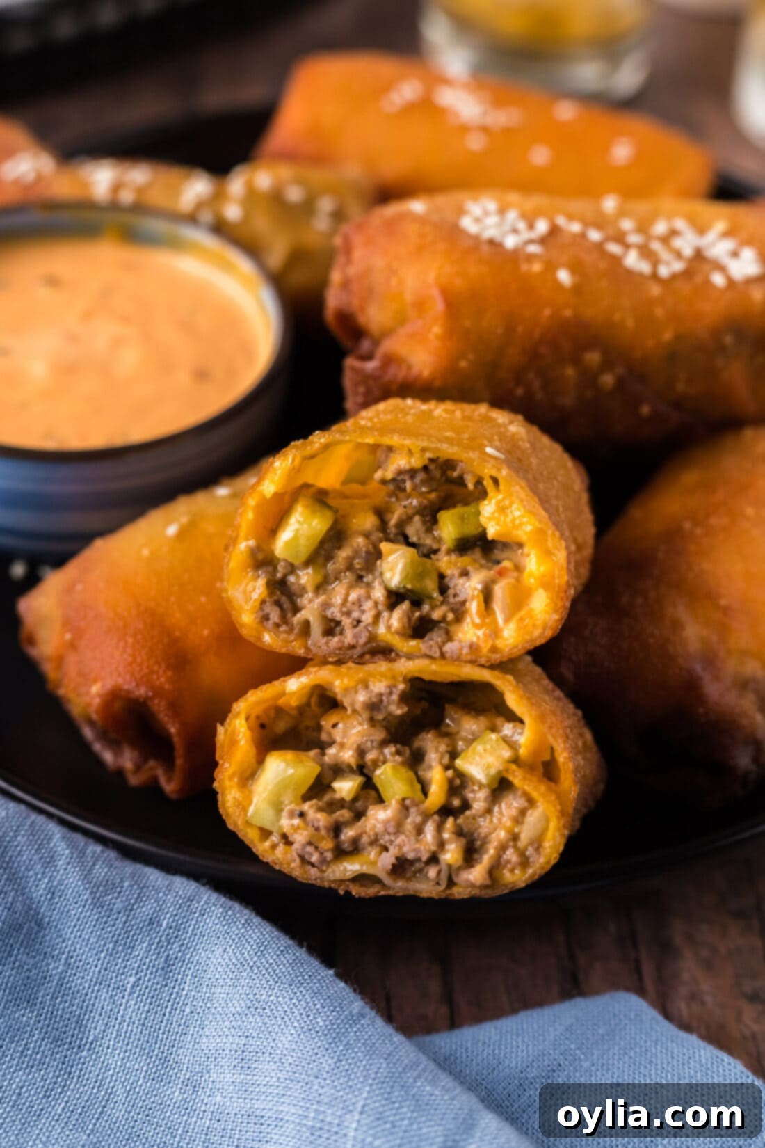 Close up photo of a Big Mac Egg Roll cut in half stacked on top of each other, revealing its savory filling.