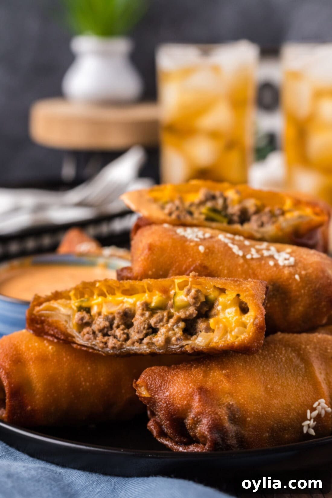 A Big Mac Egg Roll cut diagonally resting on top of other golden-brown Big Mac Egg Rolls, showcasing its delicious interior.