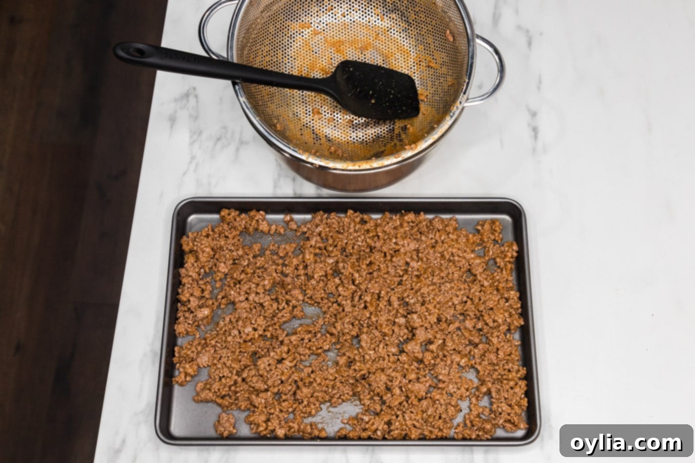 transferring ground beef mixture to a baking sheet to cool
