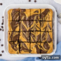 Close up photo of Pumpkin Cheesecake Brownies on a platter cut into squares