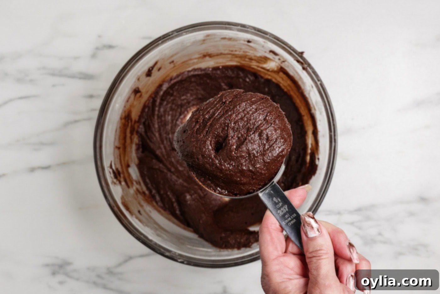 Spiced Pumpkin Swirl Cheesecake Brownies 10 Scooping out a heaping cup of brownie batter to reserve for swirling