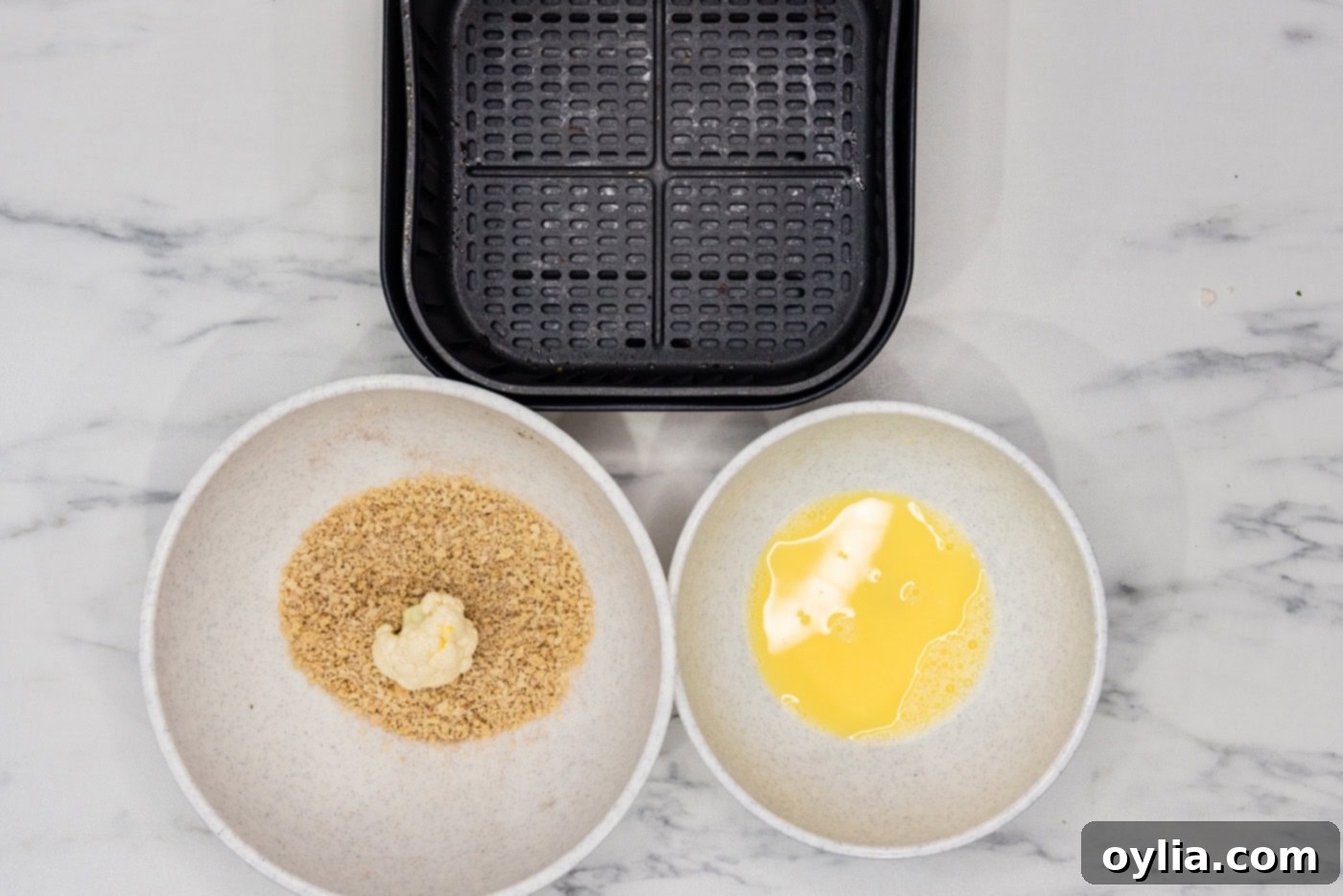 egg dredged cauliflower floret in a bowl of panko breadcrumbs