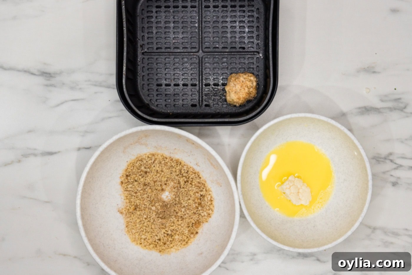 panko coated cauliflower floret in an air fryer basket