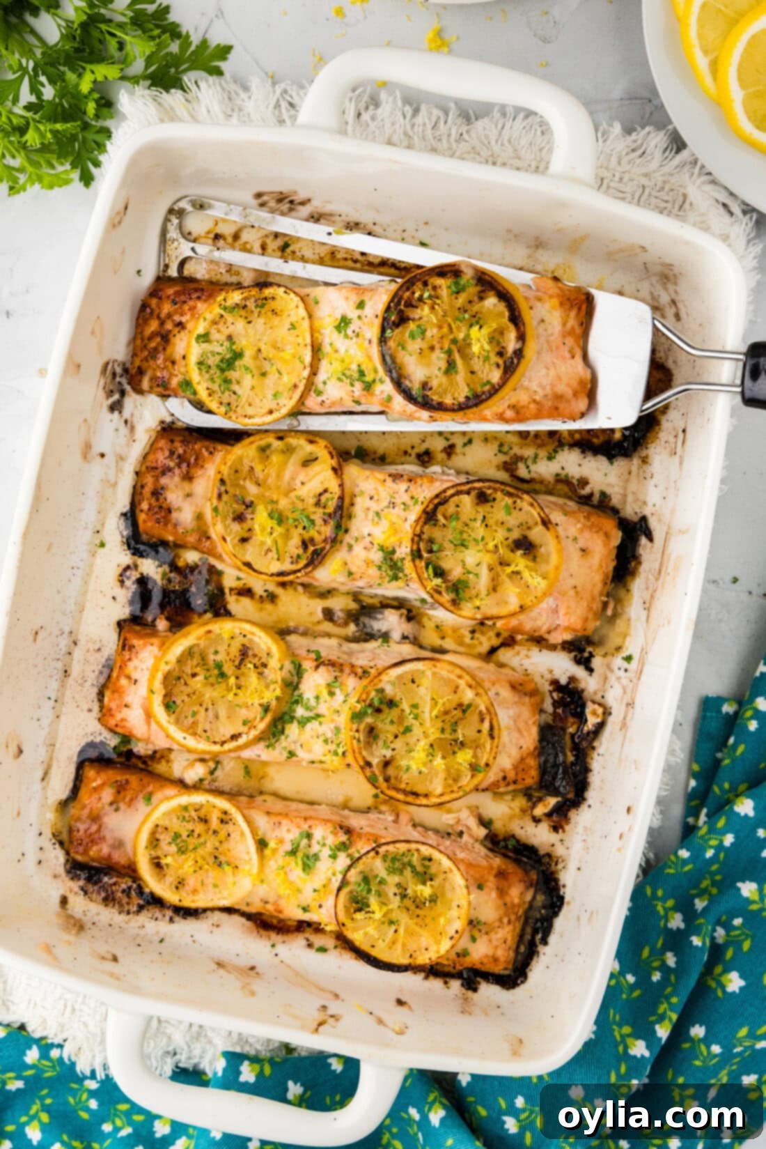 Zesty Baked Salmon 2 Baking dish of Baked Lemon Salmon with a filet being removed