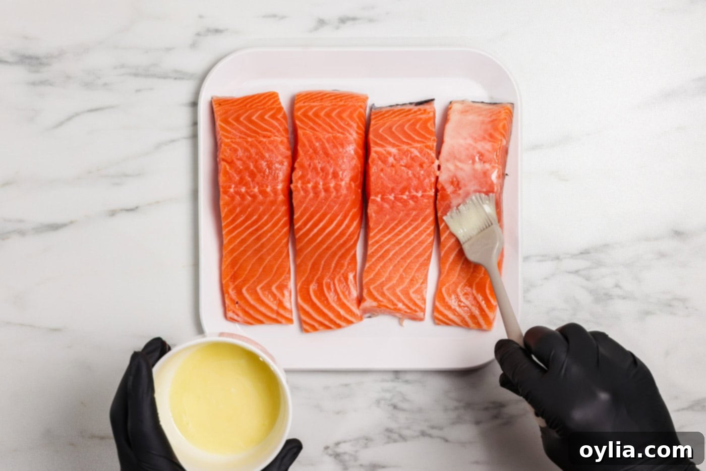 Zesty Baked Salmon 5 brushing lemon butter mixture over salmon filets