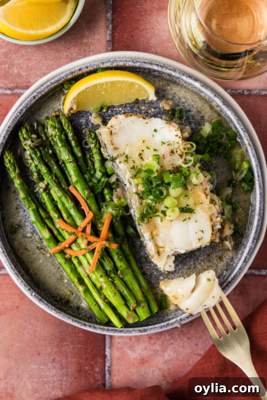 Steamed Chilean Sea Bass on a plate broken apart by a fork