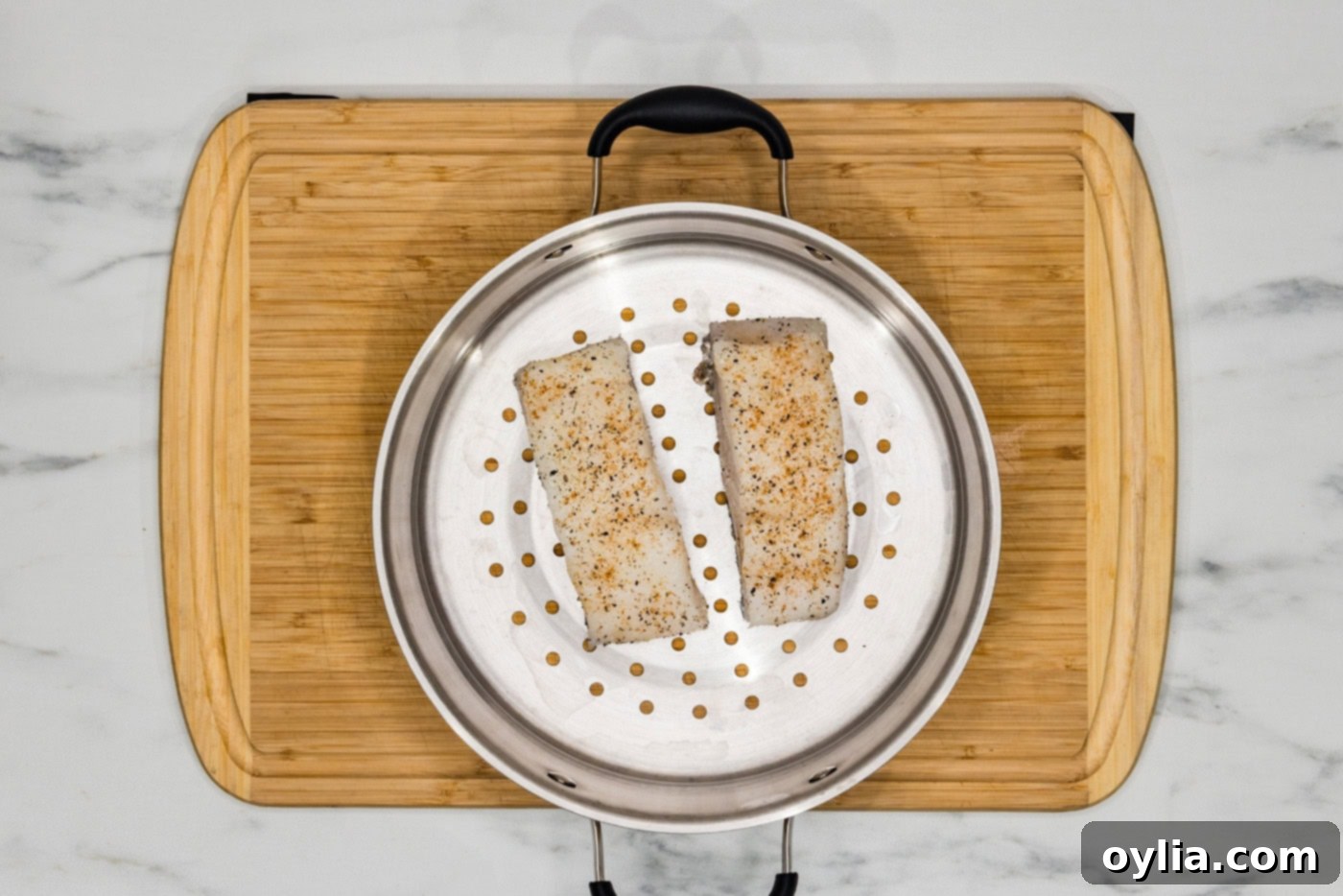 seasoned Chilean sea bass filets in a steamer basket