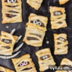 Bandaged Pastry Pockets 14 A Mummy Hand Pie artfully placed in a skeleton hand, emphasizing the festive Halloween theme and its spooky charm.