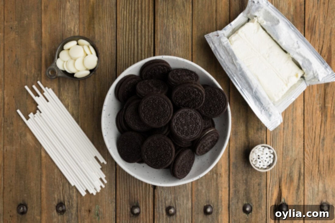 Ingredients for Mummy Pops laid out on a table, including Oreos, cream cheese, melting wafers, and candy eyeballs