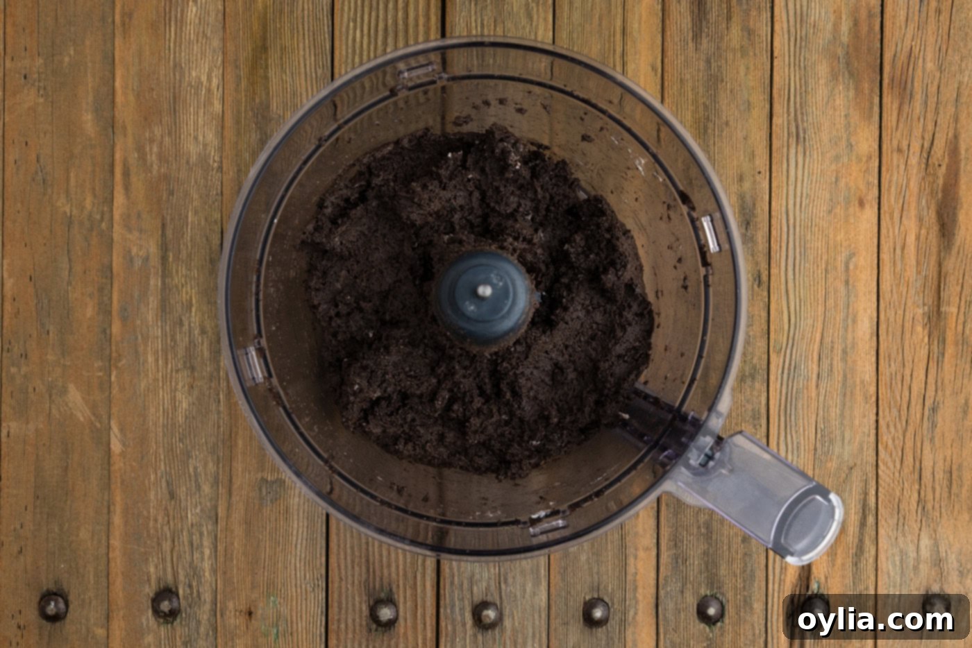 Oreo and cream cheese mixture perfectly combined in a food processor bowl, forming a thick dough