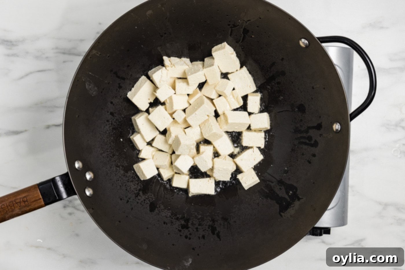 cornstarch coated tofu cubes in a wok