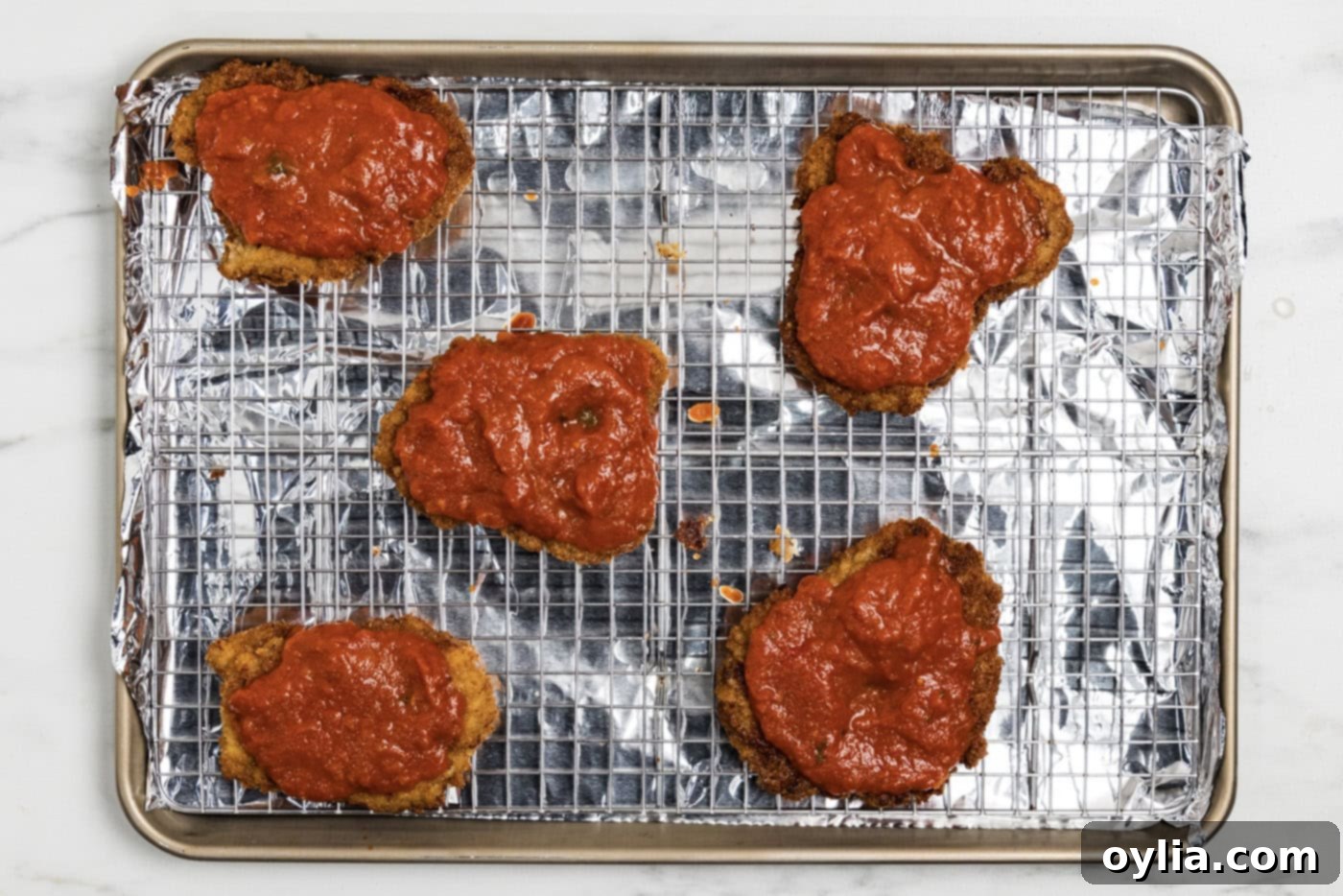 Marinara sauce over cooked breaded veal cutlets