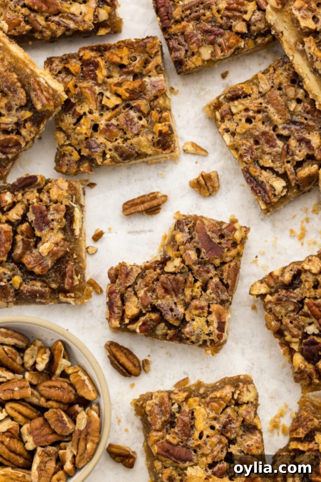 Overhead photo of Pecan Pie Bars with a bite taken out of one, showcasing layers of crust, filling, and pecans.