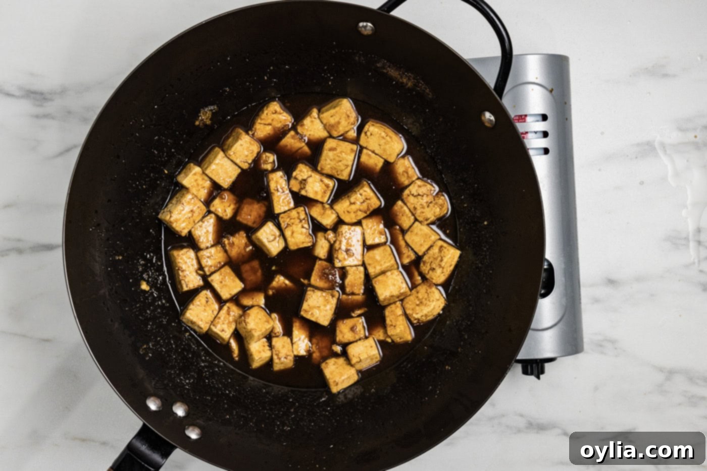 stir fried tofu in a wok with teriyaki sauce