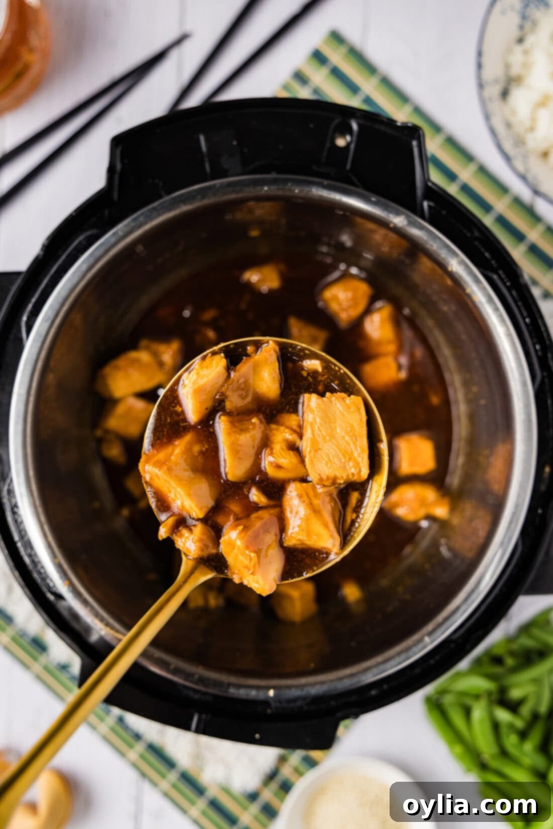 Spoonful of Instant Pot Honey Garlic Chicken held over an Instant Pot