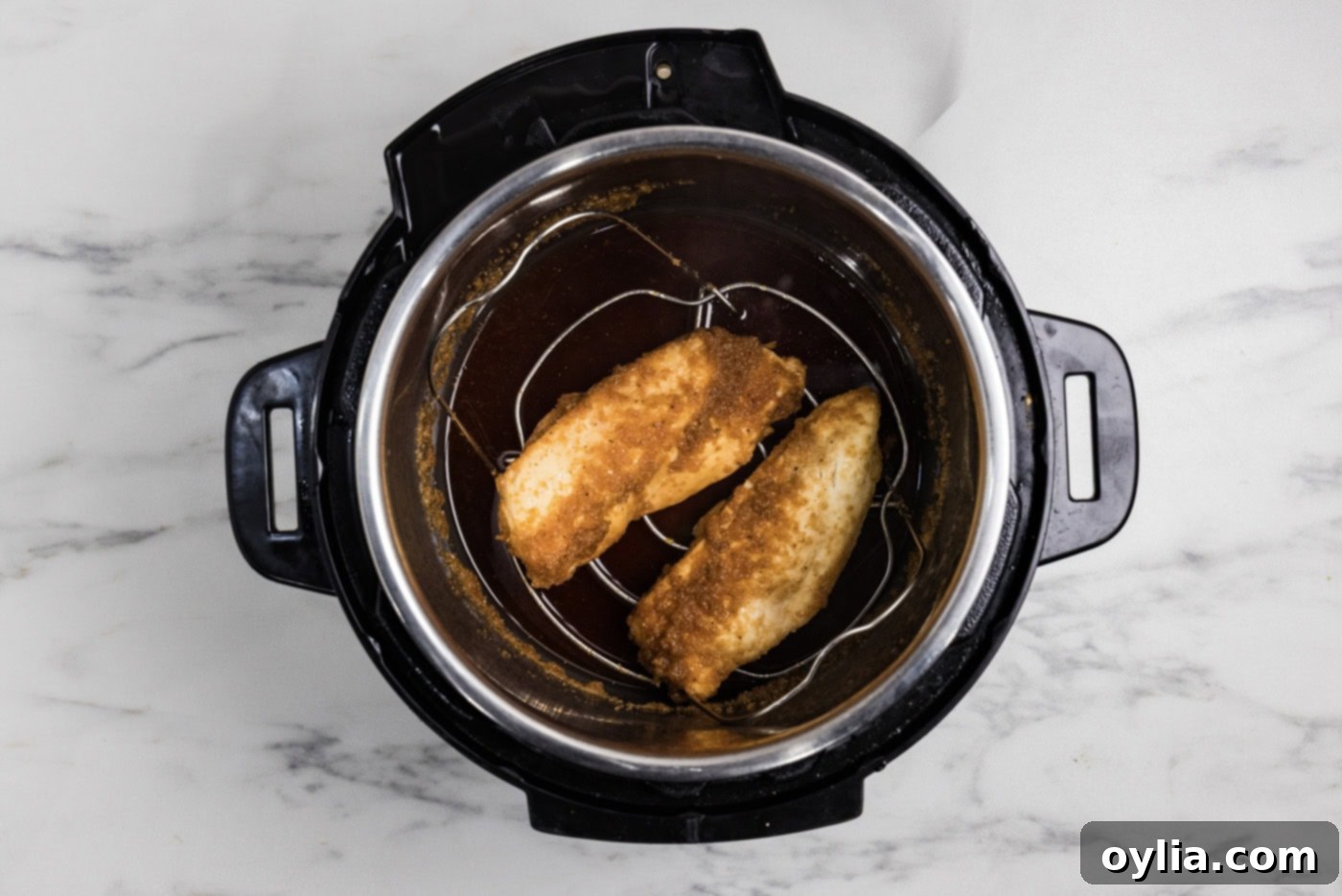 Cooked chicken breasts in honey garlic sauce in a pressure cooker