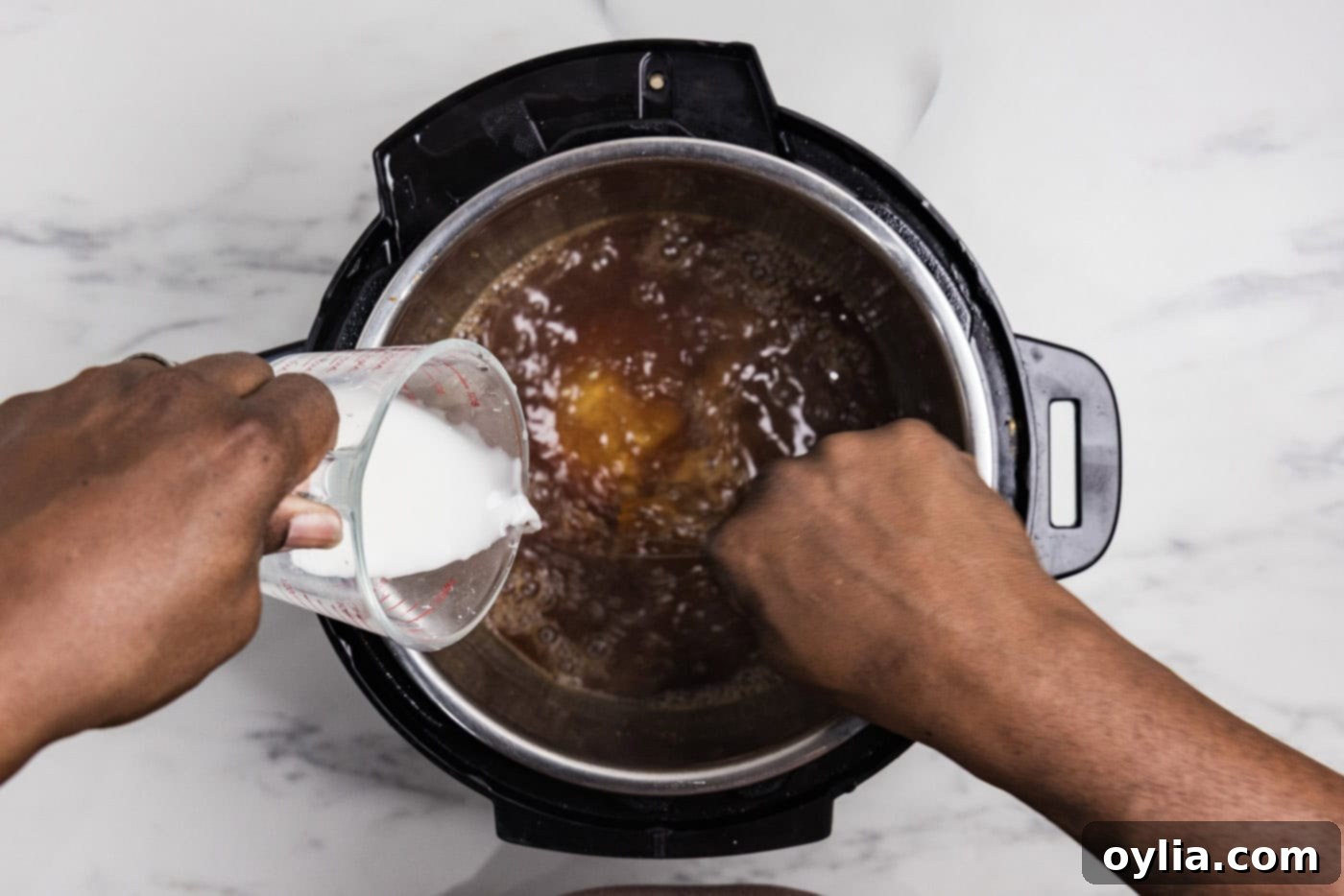 Hand whisking a cornstarch slurry into honey garlic sauce