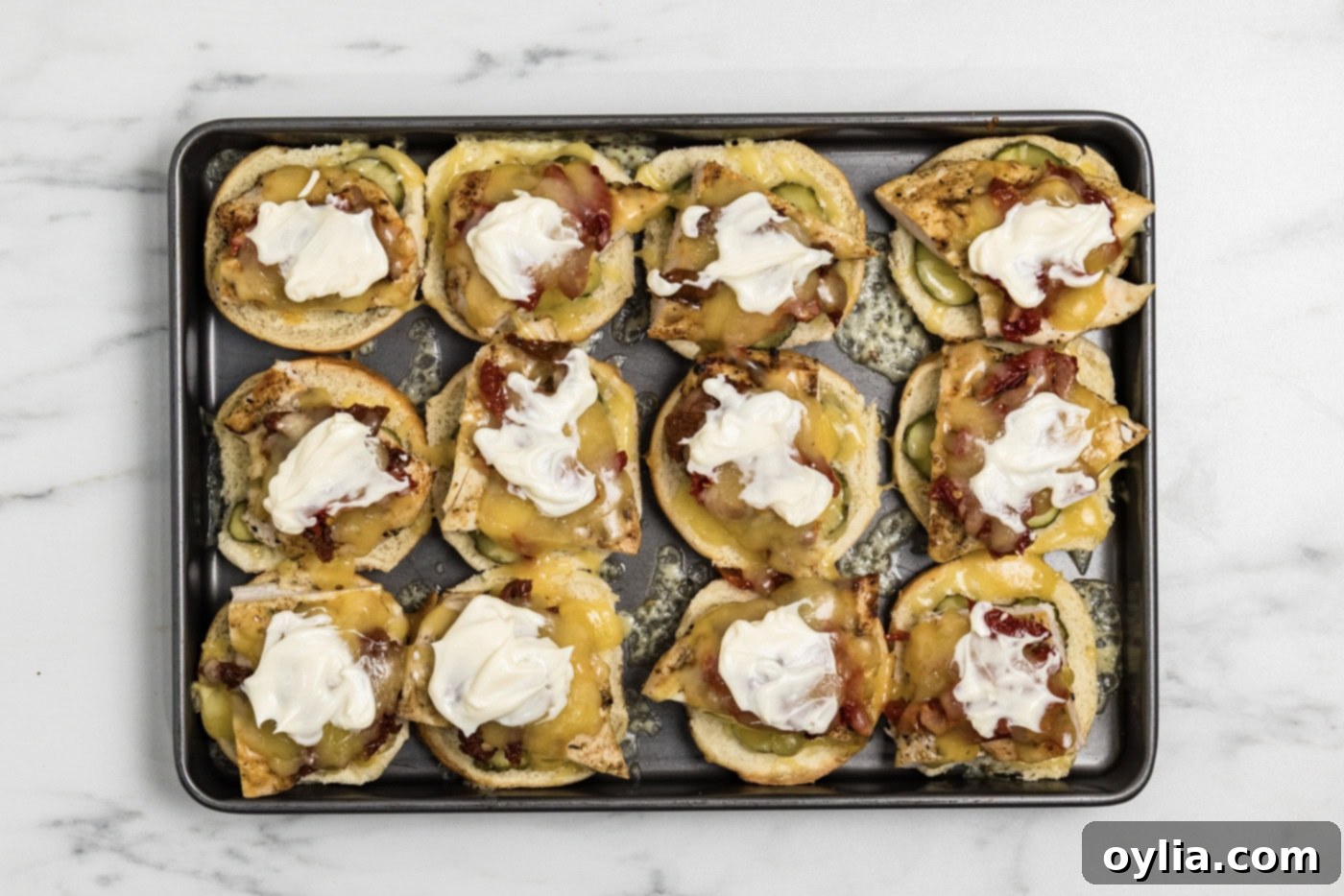 mayo dolloped on top of layered gouda chicken slider ingredients