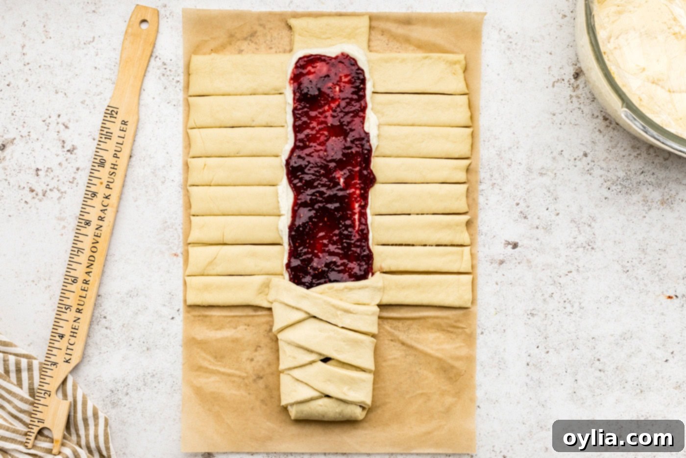 Folding dough strips overtop the filling