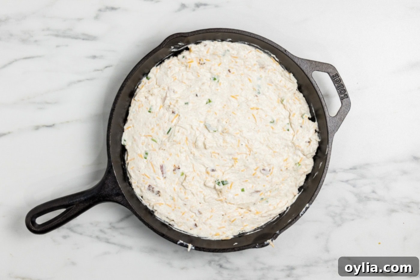 Chicken bacon ranch dip mixture in a cast iron skillet - Ready for the oven!