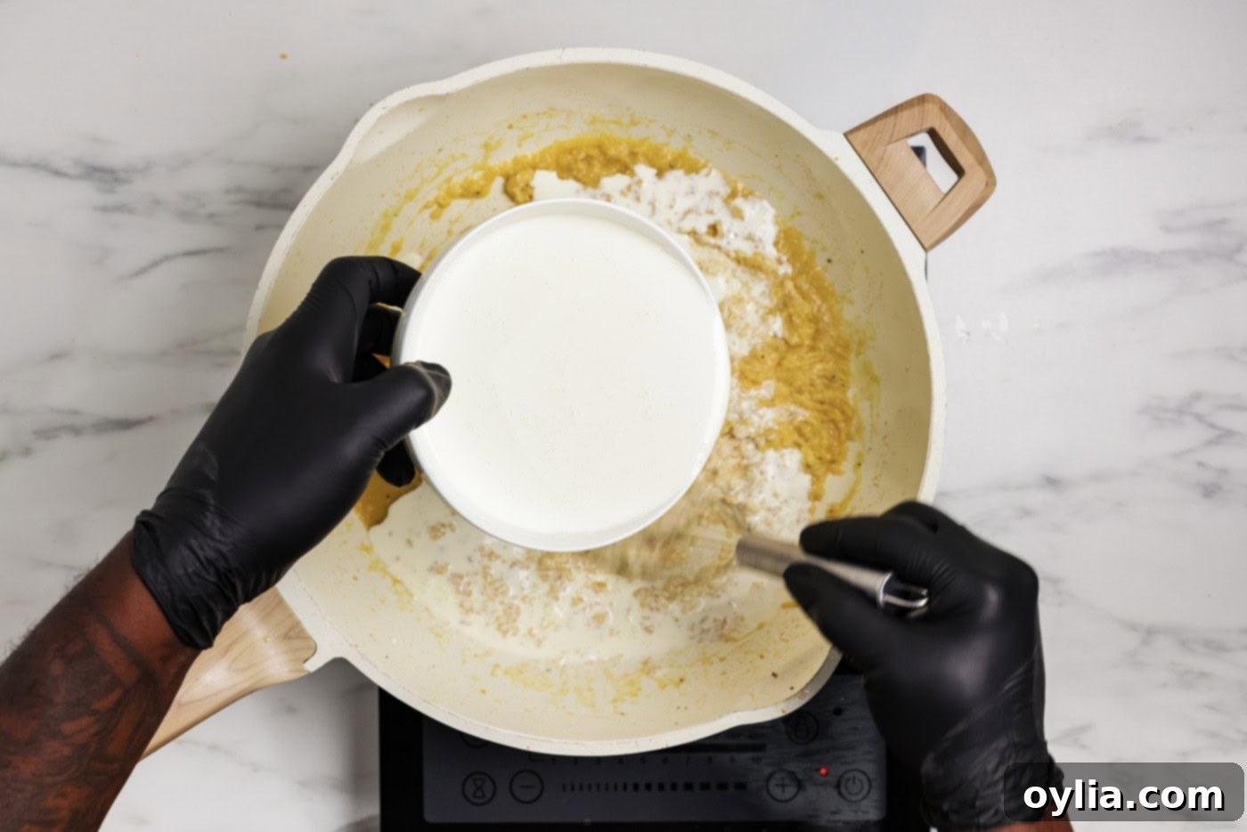 heavy cream added to skillet with a whisk
