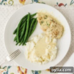 Garlic Parmesan Chicken plated with mashed potatoes and green beans