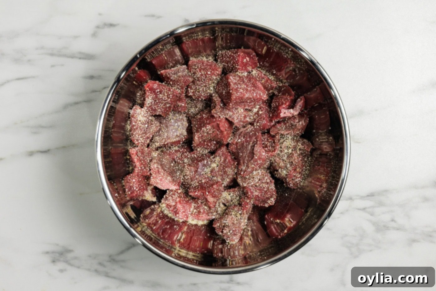 Cubed sirloin beef in a bowl with seasonings