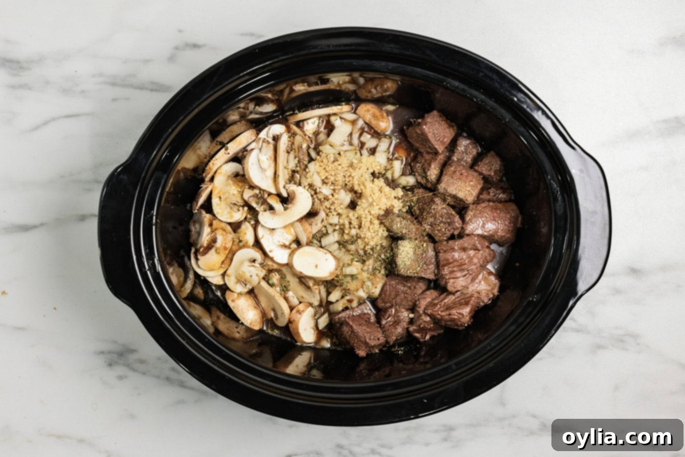 Browned sirloin cubes, onions, and mushrooms added to crockpot
